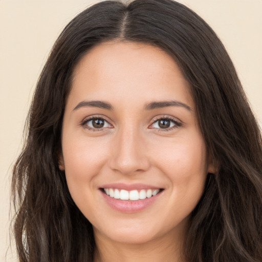 Joyful white young-adult female with long  brown hair and brown eyes