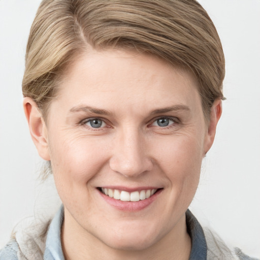 Joyful white young-adult female with medium  brown hair and grey eyes