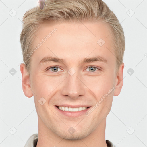 Joyful white young-adult male with short  brown hair and grey eyes