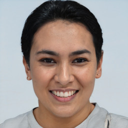 Joyful latino young-adult female with short  black hair and brown eyes