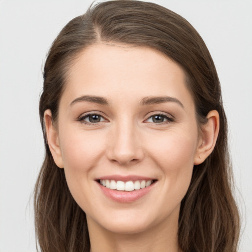 Joyful white young-adult female with long  brown hair and grey eyes