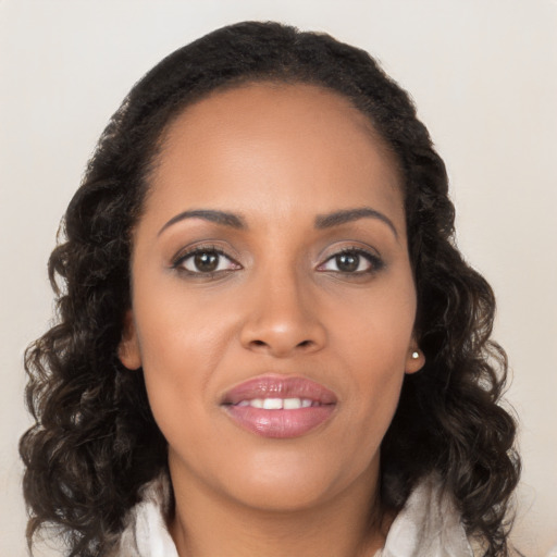 Joyful black young-adult female with long  brown hair and brown eyes