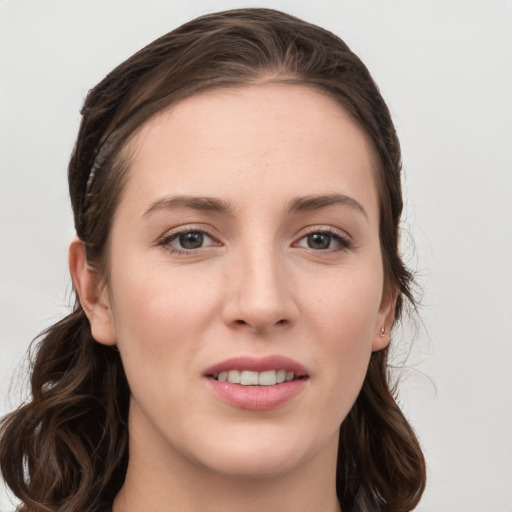 Joyful white young-adult female with long  brown hair and grey eyes