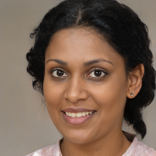 Joyful black young-adult female with medium  brown hair and brown eyes