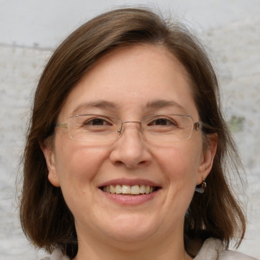 Joyful white adult female with medium  brown hair and grey eyes