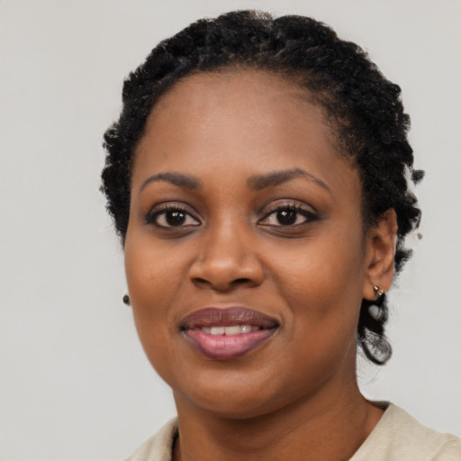 Joyful black young-adult female with short  black hair and brown eyes