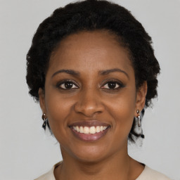 Joyful black young-adult female with medium  black hair and brown eyes