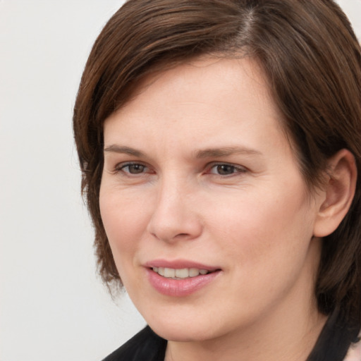 Joyful white young-adult female with medium  brown hair and brown eyes