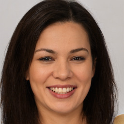 Joyful white young-adult female with long  brown hair and brown eyes