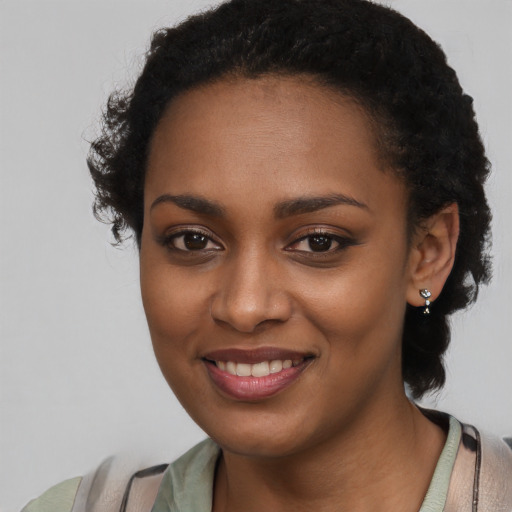 Joyful black young-adult female with short  black hair and brown eyes