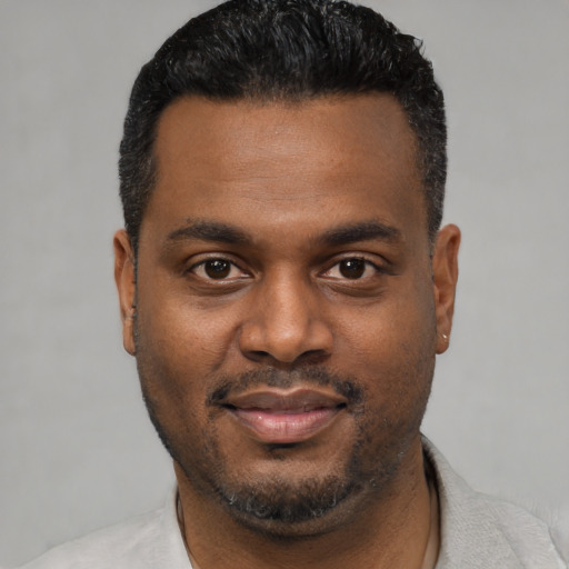 Joyful black young-adult male with short  black hair and brown eyes