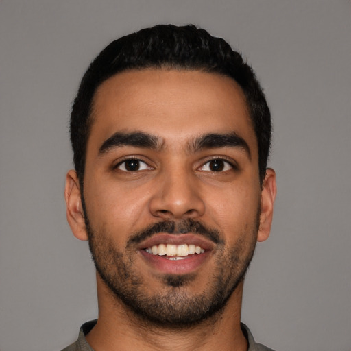 Joyful latino young-adult male with short  black hair and brown eyes