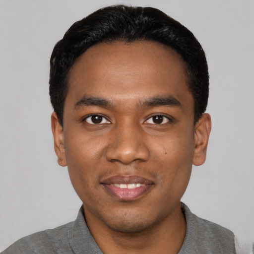 Joyful black young-adult male with short  black hair and brown eyes