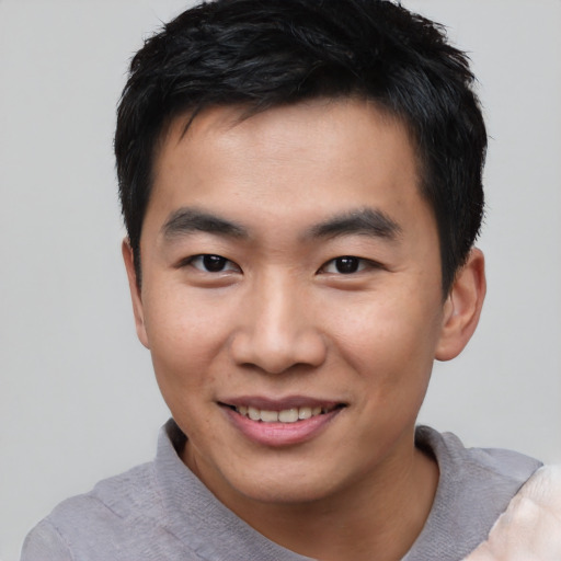 Joyful asian young-adult male with short  black hair and brown eyes