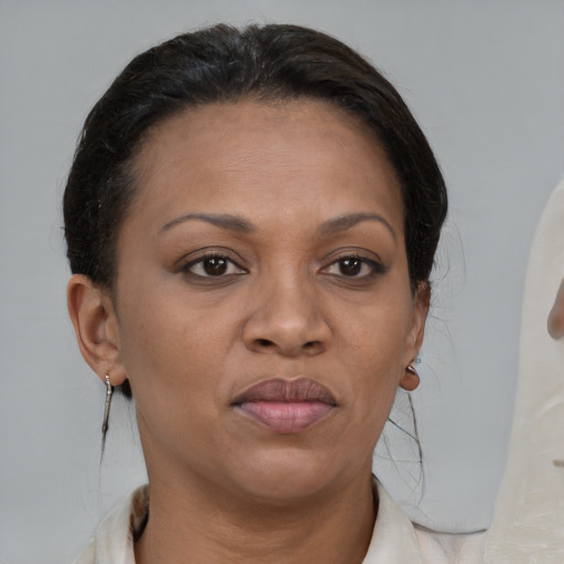 Joyful black adult female with medium  brown hair and brown eyes