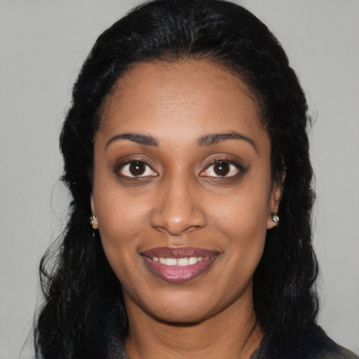 Joyful black young-adult female with long  black hair and brown eyes