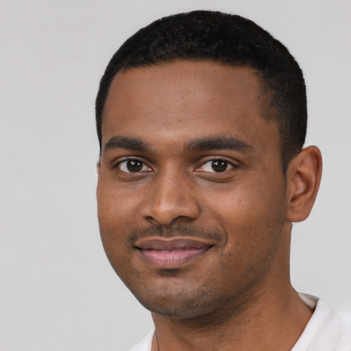 Joyful black young-adult male with short  black hair and brown eyes