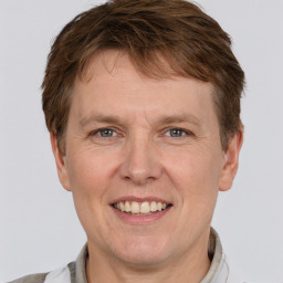 Joyful white adult male with short  brown hair and grey eyes