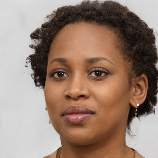 Joyful black young-adult female with medium  brown hair and brown eyes