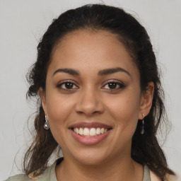 Joyful latino young-adult female with long  brown hair and brown eyes