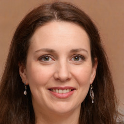 Joyful white adult female with long  brown hair and green eyes