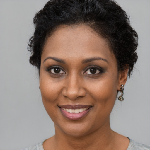 Joyful black young-adult female with short  brown hair and brown eyes
