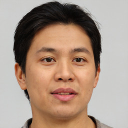 Joyful asian young-adult male with short  brown hair and brown eyes