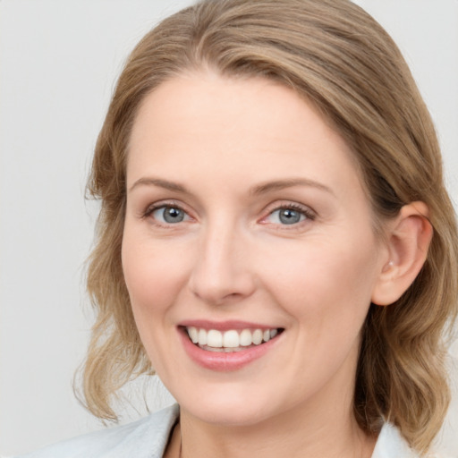 Joyful white young-adult female with medium  brown hair and blue eyes