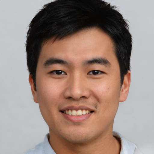 Joyful asian young-adult male with short  black hair and brown eyes