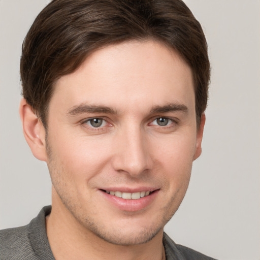 Joyful white young-adult male with short  brown hair and grey eyes