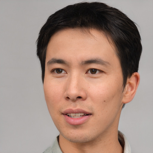 Joyful asian young-adult male with short  brown hair and brown eyes