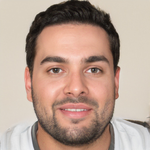 Joyful white young-adult male with short  black hair and brown eyes