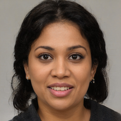 Joyful latino young-adult female with medium  brown hair and brown eyes