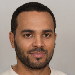 Joyful black young-adult male with short  brown hair and brown eyes