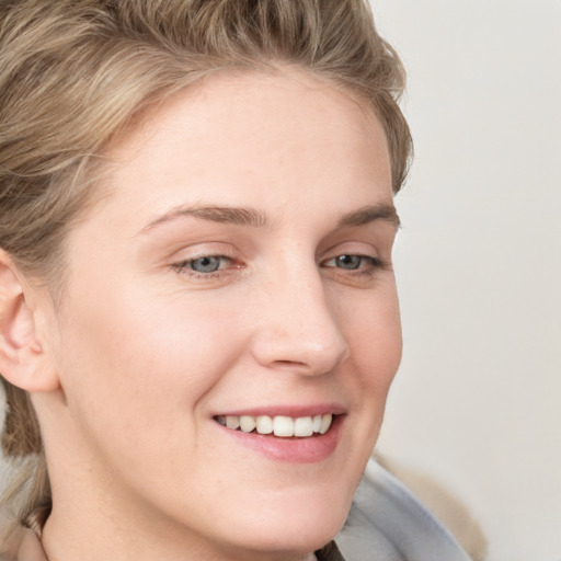 Joyful white young-adult female with short  brown hair and blue eyes