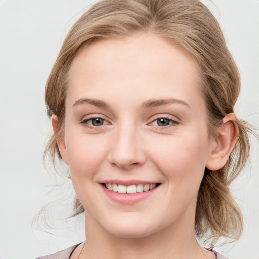 Joyful white young-adult female with medium  brown hair and blue eyes