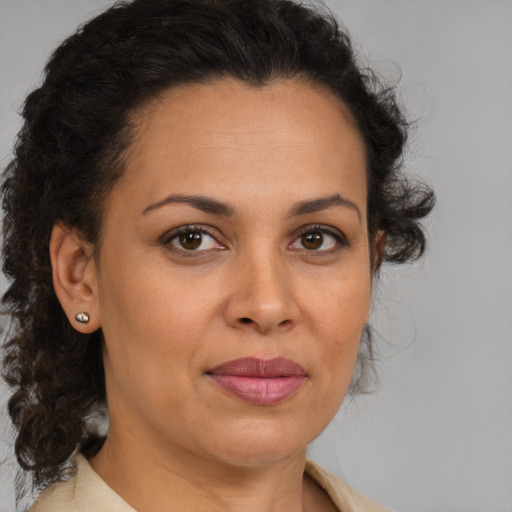 Joyful latino adult female with medium  brown hair and brown eyes