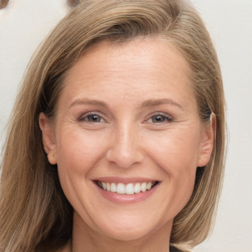 Joyful white adult female with long  brown hair and brown eyes