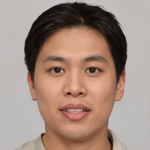 Joyful asian young-adult male with short  brown hair and brown eyes