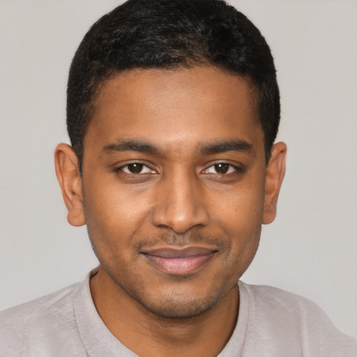 Joyful black young-adult male with short  black hair and brown eyes