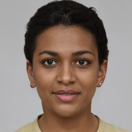 Joyful black young-adult female with short  brown hair and brown eyes