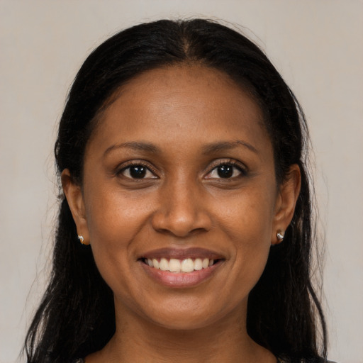 Joyful black young-adult female with long  brown hair and brown eyes