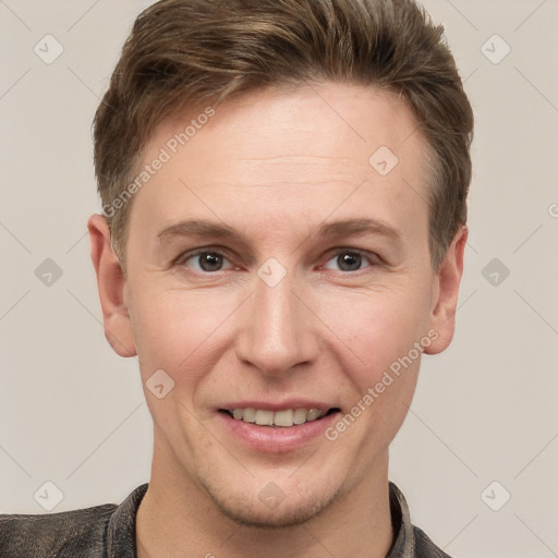 Joyful white young-adult male with short  brown hair and grey eyes