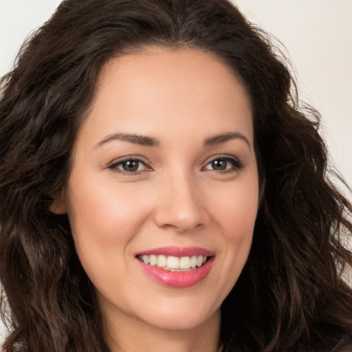 Joyful white young-adult female with long  brown hair and brown eyes