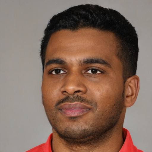 Joyful black young-adult male with short  black hair and brown eyes