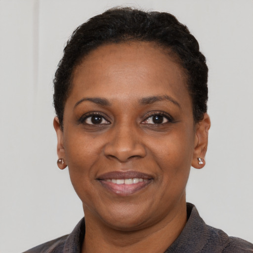 Joyful black adult female with short  black hair and brown eyes