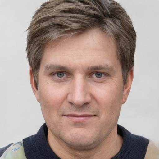 Joyful white adult male with short  brown hair and grey eyes