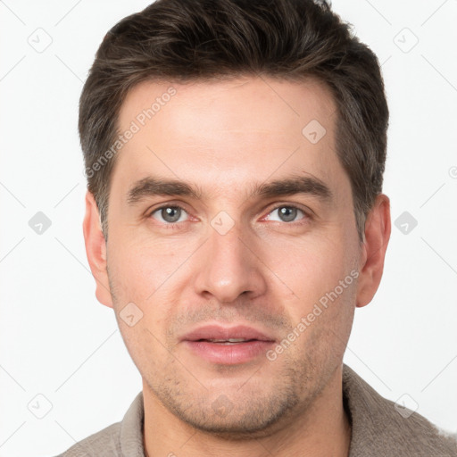 Joyful white young-adult male with short  brown hair and grey eyes