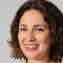 Joyful white adult female with medium  brown hair and brown eyes