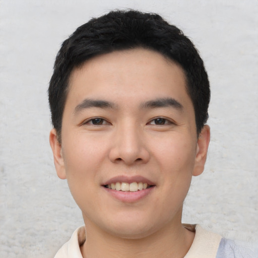 Joyful asian young-adult male with short  black hair and brown eyes